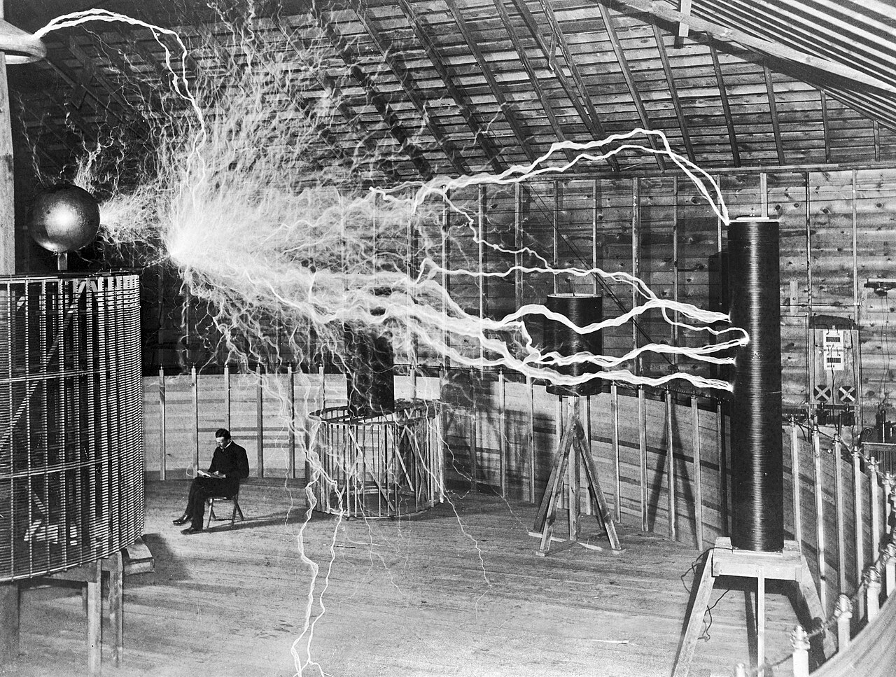 Tesla beside experimental electrical equipment.