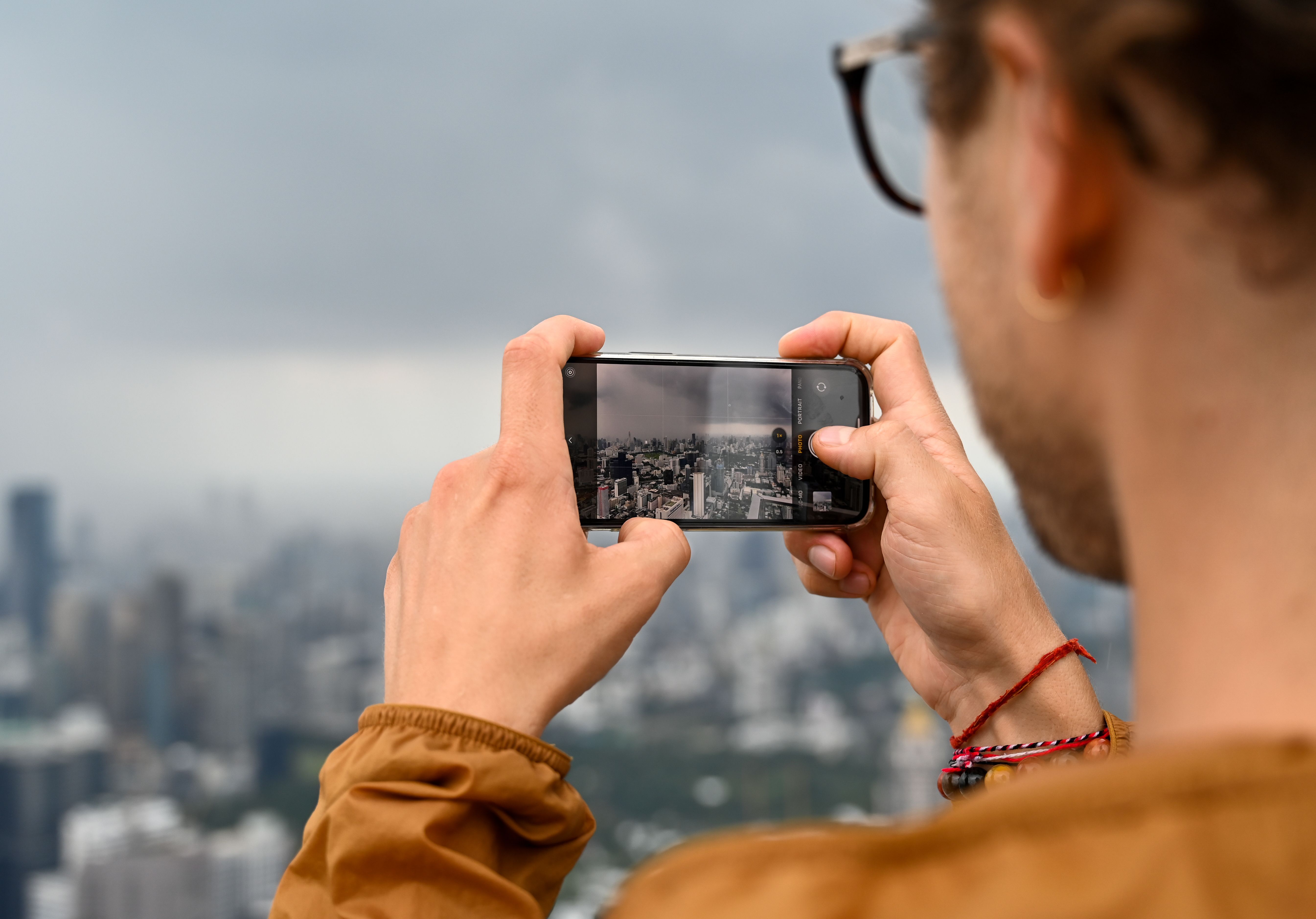 Osoba fotografiše grad mobilnim telefonom