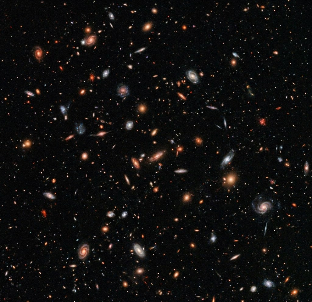 Fotografija Hubble Deep Field (1995) — preko 3.000 galaksija otkrivenih na prividno praznom delu noćnog neba. Stilizovana ili arhivska ilustracija iz dostavljenog dokumenta; njena istorijska autentičnost nije posebno potvrđena.